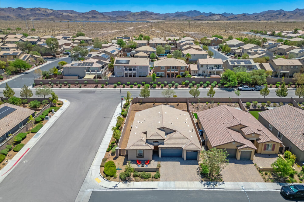 Suburban neighborhood, geometric streets, distant mountains, daytime sunlight, editorial travel photo, no people.