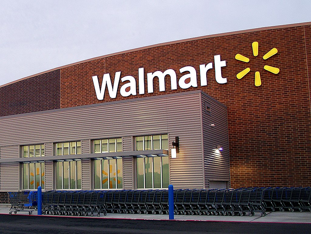 Walmart storefront, shopping carts lined up, wide shot, midday sunlight, editorial travel photo, no people.