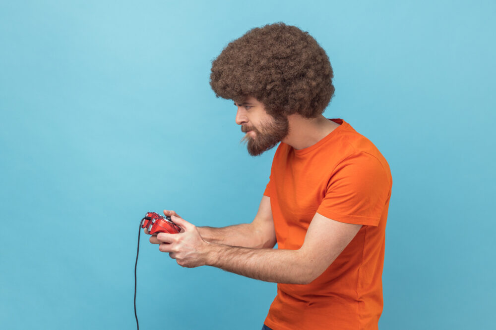 Light blue backdrop, man with curly hair and beard, mid-frame closeup, bright even light, documentary style, one person.