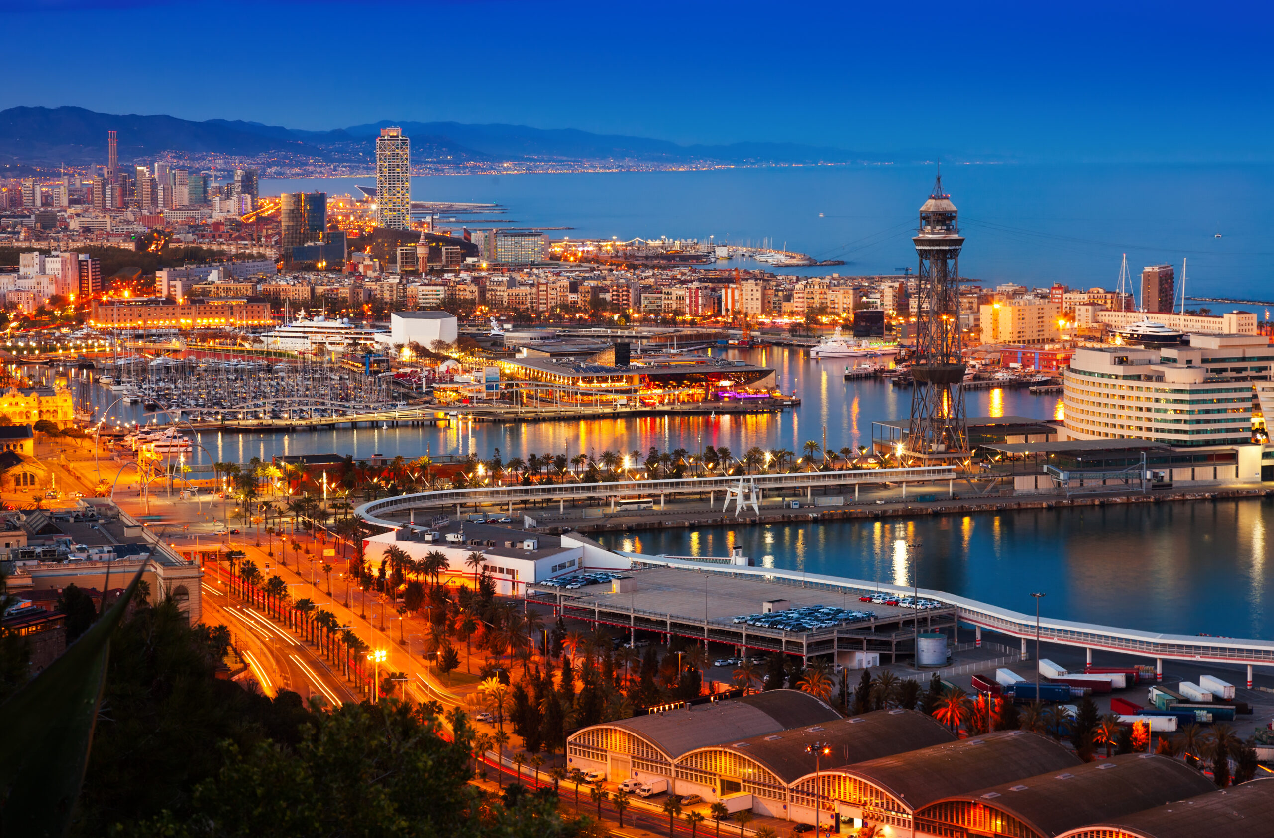 Barcelona harbor, large cruise ship, city buildings and boats, twilight blue skyline, editorial travel photo, no people.