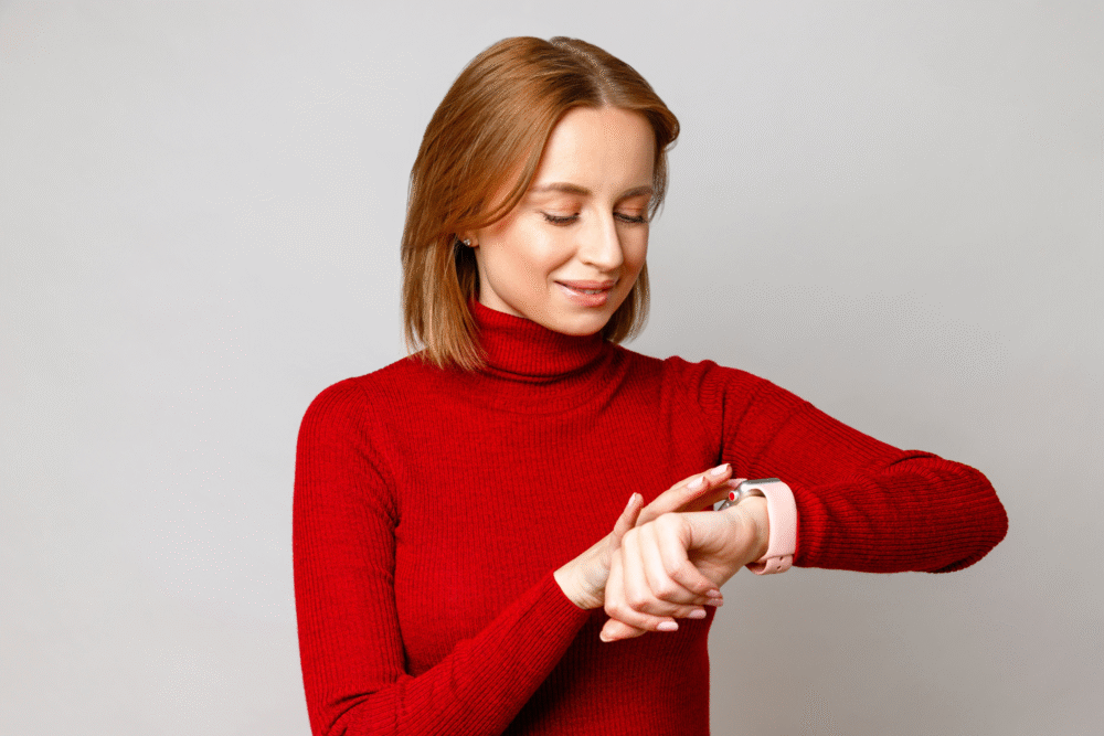 Light gray backdrop, woman with light brown hair and red turtleneck, tight mid-shot, soft daylight, editorial travel photo, people.