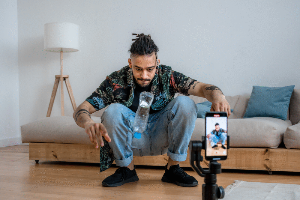 Living room, plastic water bottle flip, foreground focus, daylight indoors, documentary style photo, one man present.