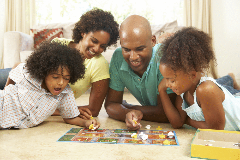Bright living room, board game in center, overhead view, daytime natural light, editorial travel photo, two adults two kids.